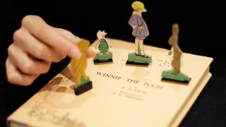 FILE - A first U.S. edition of Winnie the Pooh signed by the author A.A. Milne and illustrator E.H. Shepard is displayed with cut-outs representing characters from the book at offices of the Sotheby's auction house in London, Dec. 15, 2008.