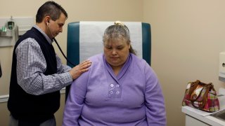 Many poorer states, especially in the South, have always had higher rates of obesity and smoking than states in the Northeast and on the West Coast. Here, a doctor listens to a patient’s heartbeat in Jackson, Kentucky.