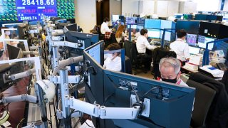 Employees wearing protective masks work in the trading room at the Daiwa Securities Group Inc. headquarters in Tokyo, Japan, on Thursday, Oct. 14, 2021.