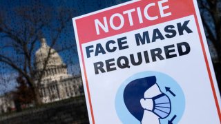 A sign reminding riders to wear a face mask to prevent the spread of Covid-19 appears on a bus on First Street outside the U.S. Capitol on Monday, January 10, 2022.