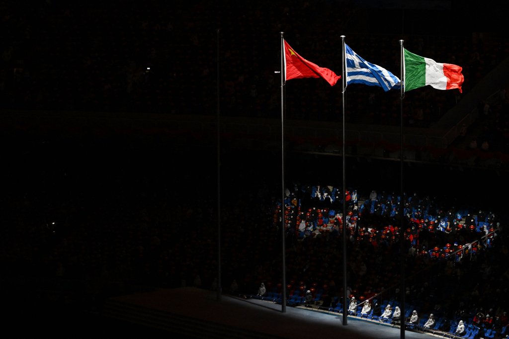 The flags of China, Greece and Italy sway in the wind during the closing ceremony of the 2022 Winter Olympic Games, Feb. 20, 2022.