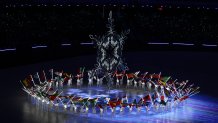 The Olympic Cauldron is seen alongside the flags of the competing countries right before it is extinguished during the 2022 Winter Olympics Closing Ceremony, Feb. 20, 2022 in Beijing.