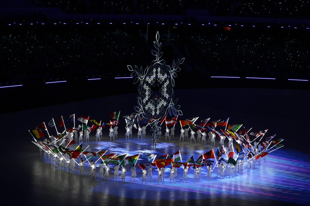 The Olympic Cauldron is seen alongside the flags of the competing countries right before it is extinguished during the 2022 Winter Olympics Closing Ceremony, Feb. 20, 2022 in Beijing.