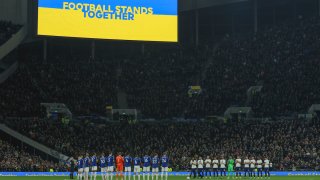 Players stand in support of Ukraine ahead of the English Premier League soccer match between Tottenham Hotspur and Everton