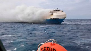 FILE - In this undated photo provided by the Portuguese Navy on Feb. 18, 2022, smoke billows from the burning Felicity Ace car transport ship as seen from the Portuguese Navy NPR Setubal ship southeast of the mid-Atlantic Portuguese Azores Islands. A large cargo vessel carrying cars from Germany to the United States has sunk in the mid-Atlantic, 13 days after a fire broke out on board. The ship’s manager and the Portuguese navy said the Felicity Ace sank Tuesday, March 1 about 400 kilometers (250 miles) off Portugal’s Azores Islands as it was being towed.