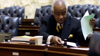 Rep. Emmett Burns, D-Baltimore County, tidies up his desk after the first day of the 2014 Maryland legislative session in Annapolis, Md., Wednesday, Jan. 8, 2014.