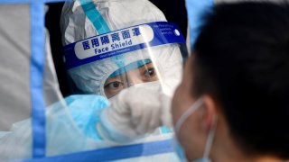 A medical worker takes a swab sample from a citizen for nucleic acid test at a testing site in Binhai New Area in north China’s Tianjin, Jan. 9, 2022.