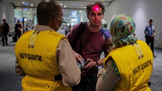 Health officer uses a thermal head to detect a monkeypox virus on arriving passengers at Soekarno-Hatta International Airport in Tangerang near Jakarta, Indonesia on May 15, 2019.