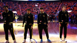 Kevon Looney #5, Moses Moody #4, Klay Thompson #11 and Nemanja Bjelica #8 of the Golden State Warriors stand for a moment of silence for the victims of the mass shooting at Robb Elementary School in Uvalde, TX prior to Game Five of the 2022 NBA Playoffs Western Conference Finals against the Dallas Mavericks at Chase Center on May 26, 2022 in San Francisco