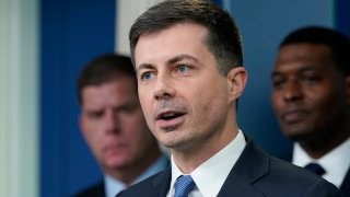 FILE - Transportation Secretary Pete Buttigieg, center, speaks during a briefing at the White House in Washington, May 16, 2022, as Labor Secretary Marty Walsh, left, and Environmental Protection Agency administrator Michael Regan, right, listen. Buttigieg says he is pushing airlines to hire more customer-service people and take other steps to help travelers this summer.