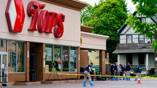 FILE - Investigators work the scene after a mass shooting at a supermarket, in Buffalo, N.Y., May 16, 2022.