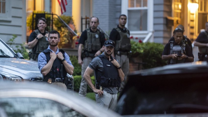 Law enforcement officers stand guard as protesters march past Supreme Court Justice Brett Kavanaugh’s home on June 8, 2022 in Chevy Chase, Maryland. An armed man was arrested near Kavanaugh’s home earlier that day, as the court prepared to announce decisions for about 30 cases.