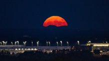 The full moon rises in the evening over Munich Airport in Hallbergmoos. 