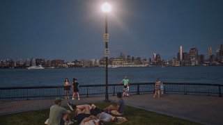 People spend time at the park at dusk during a summer heat wave, July 21, 2022