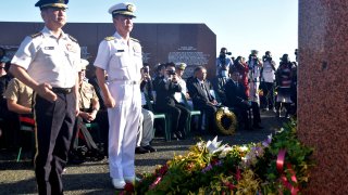This picture taken on August 7, 2022, shows Japan's Chief of Staff, Joint Staff General Koji Yamazaki (L) paying his respects during a ceremony