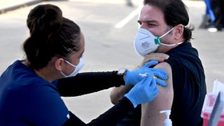 Thomas Holland gets his second booster shot against COVID-19 from a nursing student, at Long Beach City College in Long Beach on Wednesday, March 30, 2022.