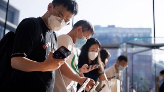 People look at Apple Inc’s new iPhone 14 as its models go on sale in Beijing, China, September 16, 2022.