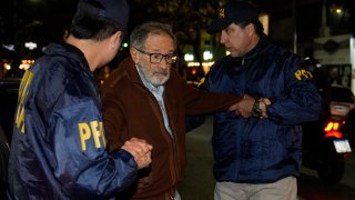 FILE - Police escort Juan Percowicz to serve pre-trial detention at his home in Buenos Aires, Argentina, Aug. 30, 2022.