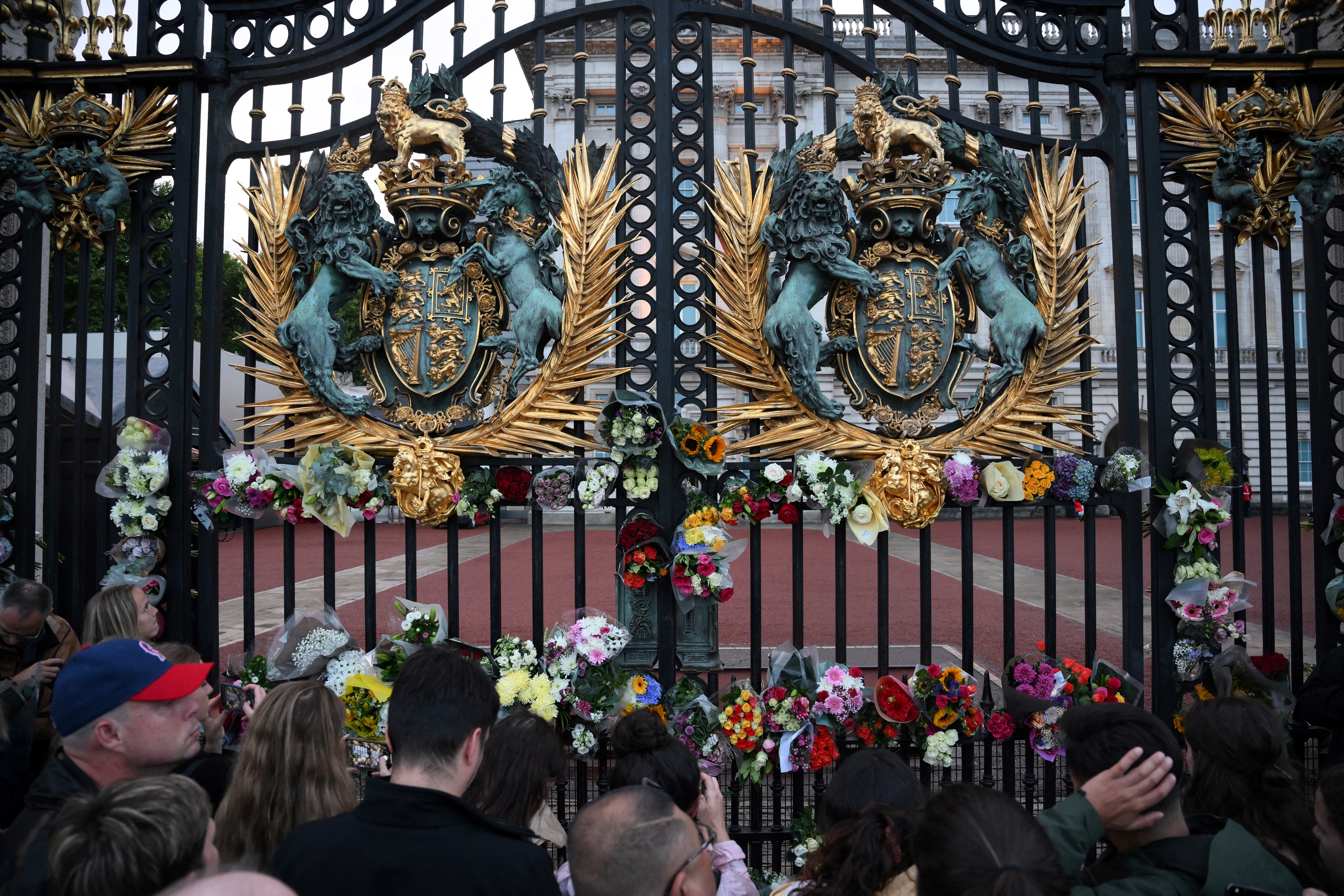 Mourners lay flowers on the gate of Buckingham Palace in London after it was announced that Queen Elizabeth II has died, Sept. 8, 2022.