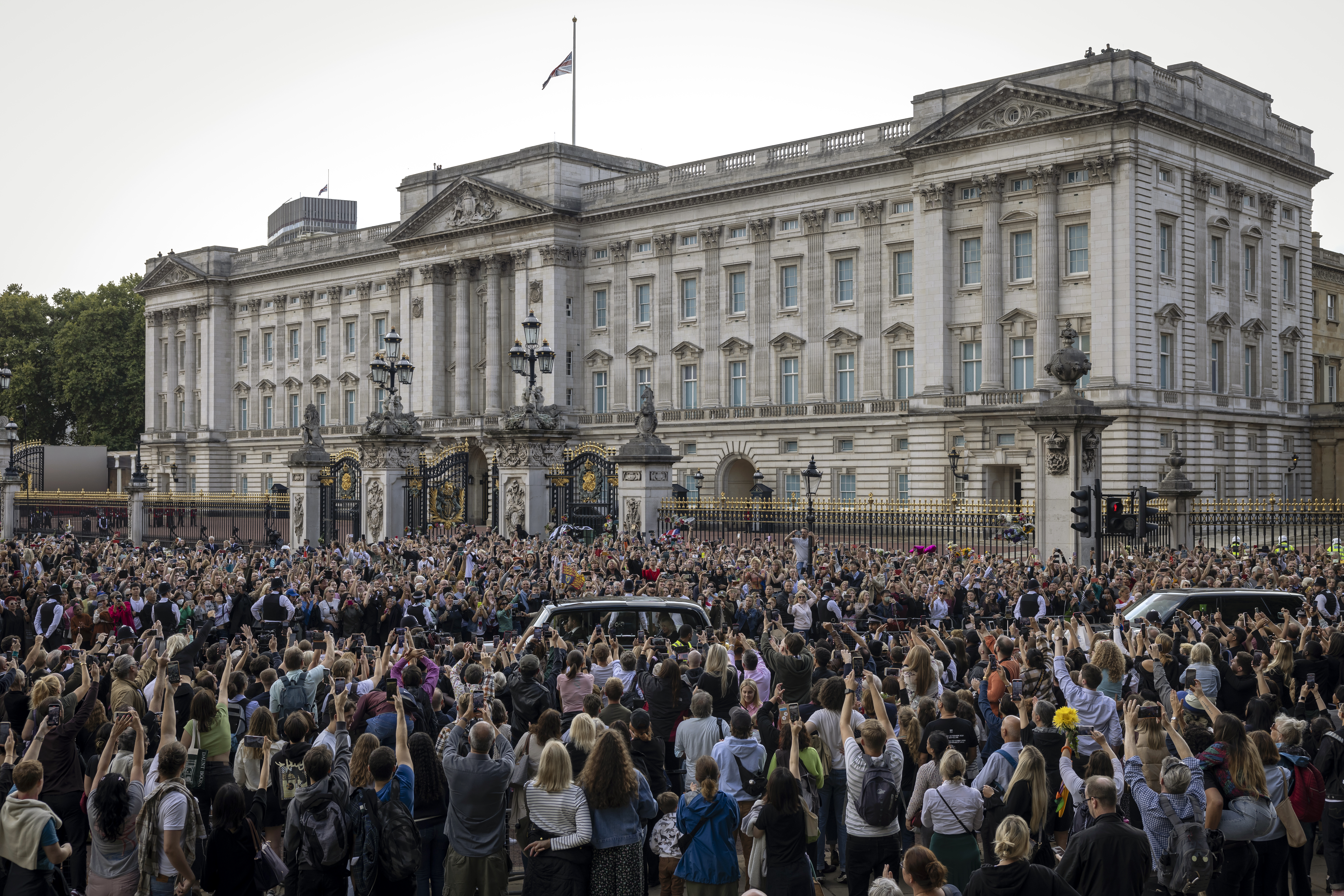 The car carrying King Charles III and Camilla, Queen Consort, arrives at Buckingham Palace with the Union Flag at half mast, Sept. 9, 2022, in London.