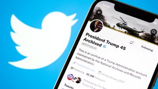 In this photo illustration, former U.S. President Donald Trump’s archived Twitter account is shown on a phone screen with the Twitter logo in the background.