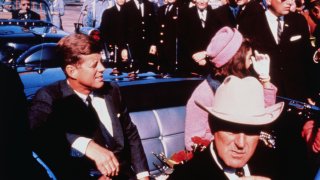 (Original Caption) Texas Governor John Connally adjusts his tie (foreground) as President and Mrs. Kennedy,