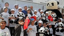 Children carry a stuffed panda toy as the pose for a picture at the Panda Park in Al Khor on October 19, 2022. - Qatar became the first Middle Eastern country Wednesday to receive Chinese giant pandas -- Suhail and Soraya -- who, in true Gulf fashion, took up residence in luxury air-conditioned quarters. The Chinese government sent the animals as gift to mark the World Cup that starts November 20. China has not qualified for the event, but is a major customer for Qatar's natural gas. (Photo by DENOUR / AFP) (Photo by DENOUR/AFP via Getty Images)