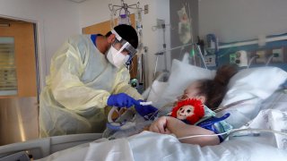 Respiratory Therapist Adel Al Joaid treats Melissa Wartman, a COVID-19 patient, in the ICU at Rush University Medial Center on January 31, 2022 in Chicago, Illinois.