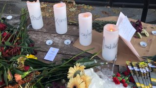 Candles and flowers are left at a make-shift memorial honoring four slain University of Idaho students outside the Mad Greek restaurant in downtown Moscow, Idaho, on Tuesday, Nov. 15, 2022.