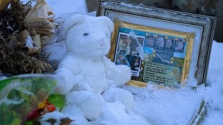 Flowers, a stuffed animal, and a framed image featuring the photos of the four people found dead at a house on Nov. 13, 2022 in Moscow, Idaho, rest in the snow in front of the house on Tuesday, Nov. 29, 2022.