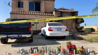 FILE – Dozens of candles sit placed on the sidewalk along with bouquets of flowers and stuffed animals outside a charred home in Riverside, Calif., Wednesday, Nov. 30, 2022. Authorities say that a Virginia sheriff’s deputy who police say traveled to California to kill several family members of a 15-year-old girl he tried to sexually extort online killed himself with a government-issued firearm. (AP Photo/Amy Taxin, File)
