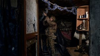 A Ukrainian soldier decorates a frontline position during fights with Russian forces near Maryinka, Donetsk region, Ukraine, Friday, Dec. 23, 2022. (AP Photo/Libkos)