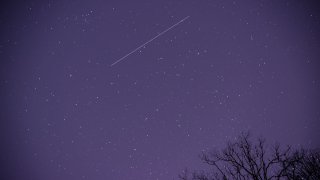 FILE - A meteor streaks across the night sky in Nashville, Tennessee, as the Geminid meteor shower reached its maximum in the early morning of Dec. 14, 2021.