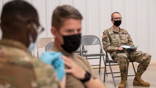 FILE – A soldier watches another soldier receive his COVID-19 vaccination from Army Preventative Medical Services on Sept. 9, 2021 in Fort Knox, Kentucky.