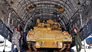 A Soldier backs an M32 Bradley fighting vehicle into a C-17 cargo bay guideded by Master Sgt. Krystopher Schwandt, loadmaster, for transport back to Fort Benning GA. Sept. 19, 2012.