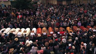 Residents surround coffins during a vigil for the more than a dozen people who died during the unrest in Juliaca, Peru