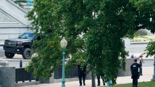 A man is apprehended after being in a pickup truck parked on the sidewalk in front of the Library of Congress’ Thomas Jefferson Building, as seen from a window of the U.S. Capitol, Aug. 19, 2021, in Washington.