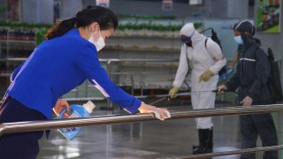 FILE - In this photo published on June 28, 2022 by the North Korean government, North Korean employees disinfect a facility