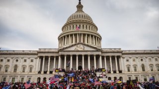 A large group of pro-Trump protesters stand on the East steps of the Capitol Building after storming its grounds on January 6, 2021 in Washington, DC. (Photo by Jon Cherry/Getty Images)