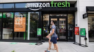 People walk past an Amazon Fresh store in Washington, DC, on August 26, 2021.