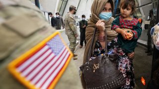 A day after U.S. forces completed its troop withdrawal from Afghanistan, refugees board a bus taking them to a processing center upon their arrival at Dulles International Airport in Dulles, Virginia, September 1, 2021.