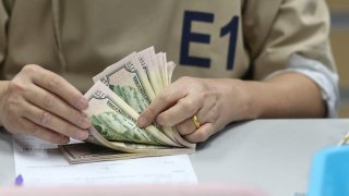 A bank employee counts U.S. dollar notes at a Kasikornbank in Bangkok, Thailand, January 26, 2023.
