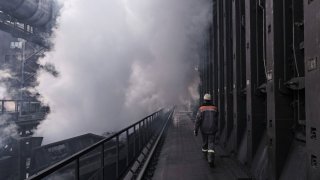 A coke plant worker beside coke battery ovens at the ArcelorMittal steel plant in Kryvyi Rih, Ukraine, in March 2019.
