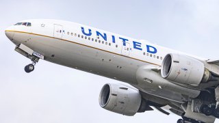 United Airlines Boeing wide body 777-200 aircraft as seen during take off and flying phase, passing in front of the air traffic control tower while the plane is departing from Amsterdam Schiphol Airport AMS towards Houston IAH in the United States of America as flight UA21.