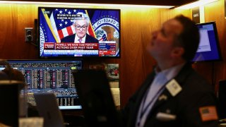 A trader works on the floor of the New York Stock Exchange (NYSE) as a screen shows Federal Reserve Board Chairman Jerome Powell during a news conference following a Fed rate announcement, in New York City, February 1, 2023.