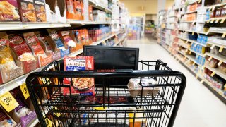 A grocery cart sits in an aisle at a grocery store in Washington, DC, on February 15, 2023.