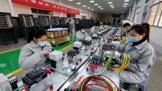 Workers make charging equipment for new energy vehicles at a workshop of Shandong Dingsheng Electric Equipment in Zaozhuang, east China’s Shandong province.