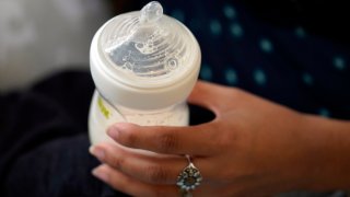 FILE – A mother holds a bottle of baby formula as she feeds her infant son, Friday, May 13, 2022, in San Antonio.