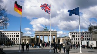 From left, the German flag, the Union Jack flag and the European Union flag wave in front of the Brandenburg Gate