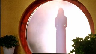A participant stands behind a door, hiding her identity, on Netflix’s “Love is Blind” reality dating show.